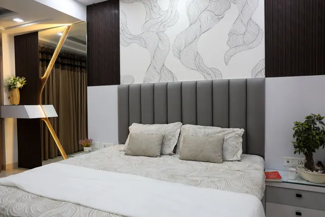 Minimal bedroom with teal upholstered bed, cove ceiling lighting, and built-in wardrobe